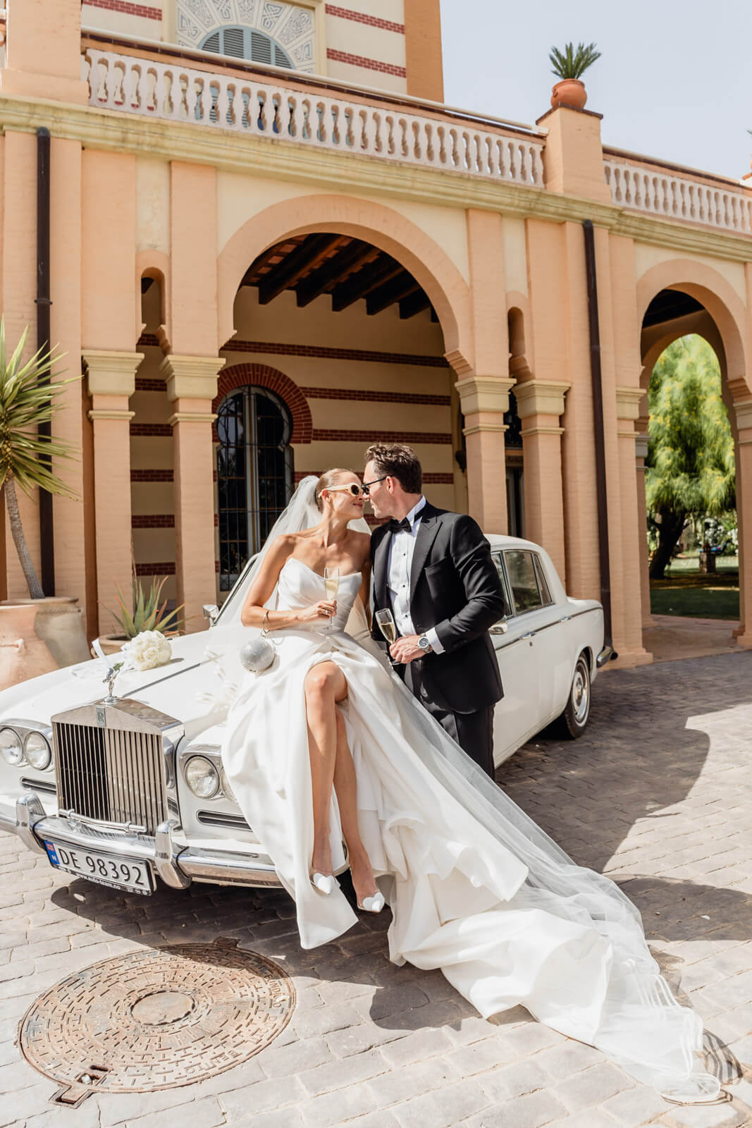 Elopements: couple beside a vintage car at a Barcelona estate