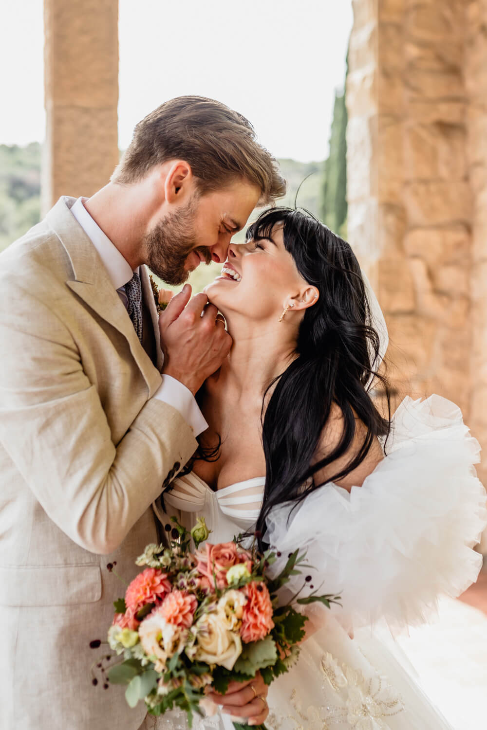 Weddings: bride and groom about to kiss holding a bouquet