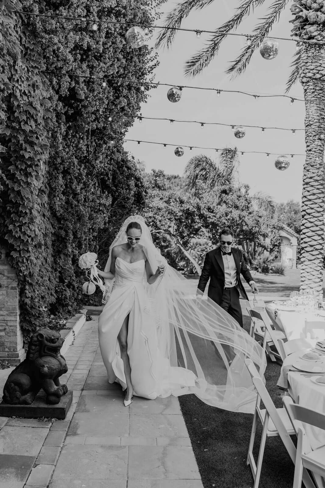 Kristina and Bjørn beneath a flowing veil among garden lights